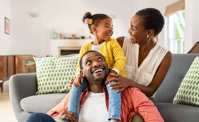 Cheerful,Little,Girl,Sitting,On,Father,Shoulder,While,Playing,With