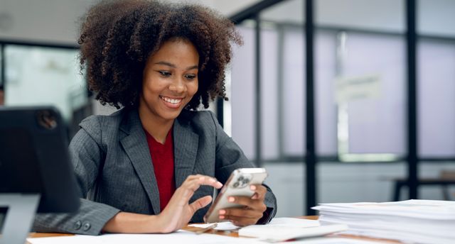 Happy,Black,Businesswoman,Smiling,While,Reading,A,Text,Message,On